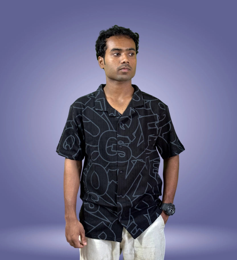 Front-facing model wearing black typographic shirt with hands on hips