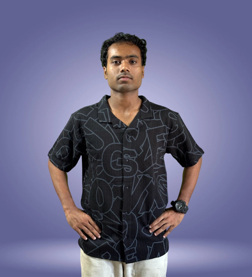 Front-facing model wearing black typographic shirt with hands on hips