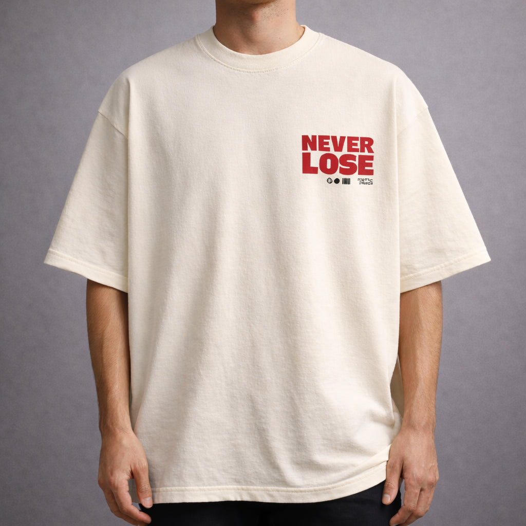 Cream oversized T-shirt with a small red “NEVER LOSE” graphic printed on the left chest, worn by a model against a neutral grey background.
