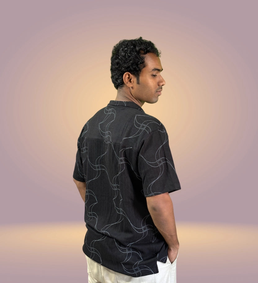 Side view of black wavy abstract print shirt on model