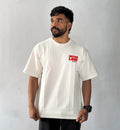 Male model wearing oversized cream Never Lose graphic T-shirt with minimalist red chest print streetwear style